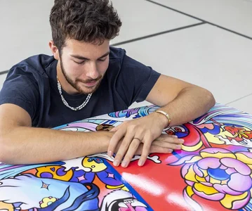 A person sitting in front of a piece of art