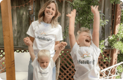 An adult with two children wearing LifeIsBright shirts