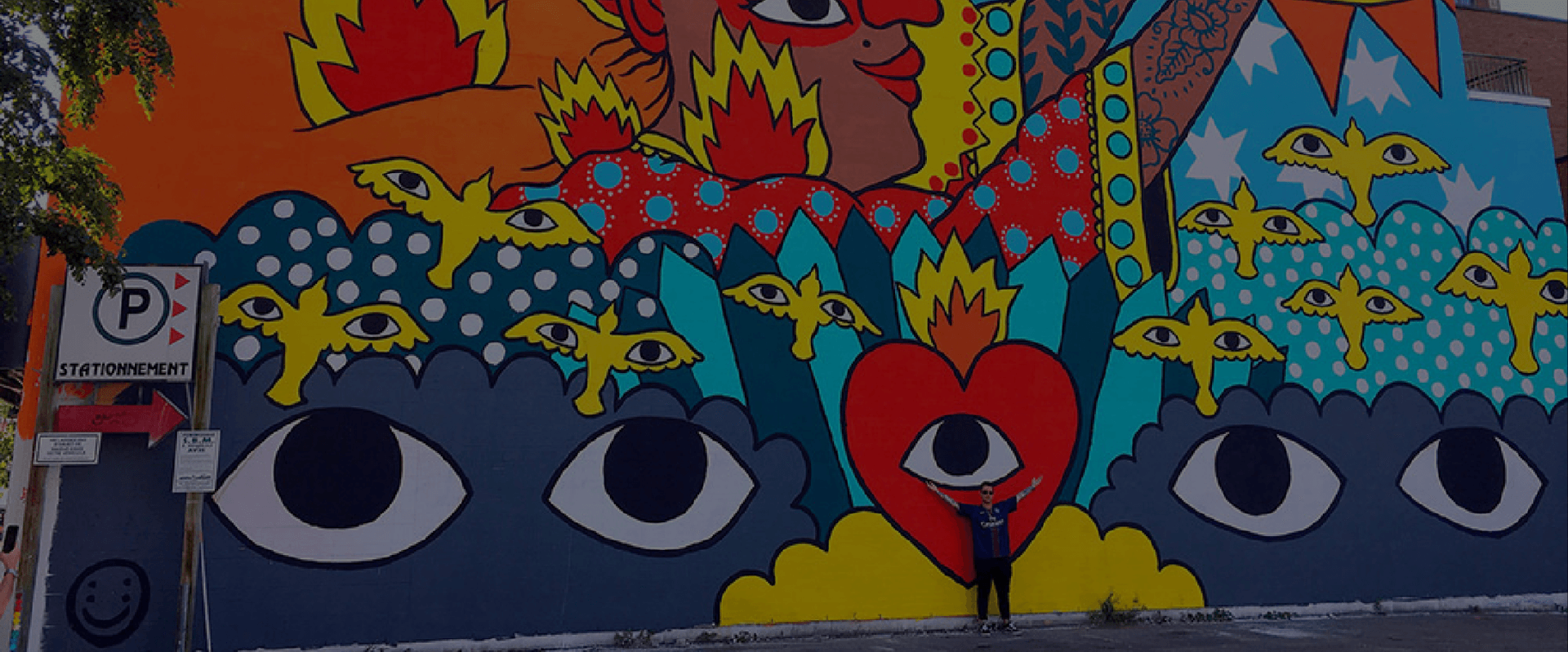 A person standing in front of a large wall painting