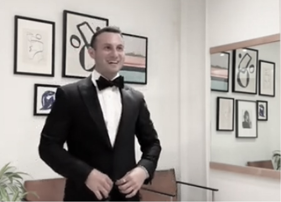 A person in front of a mirror in a black tuxedo